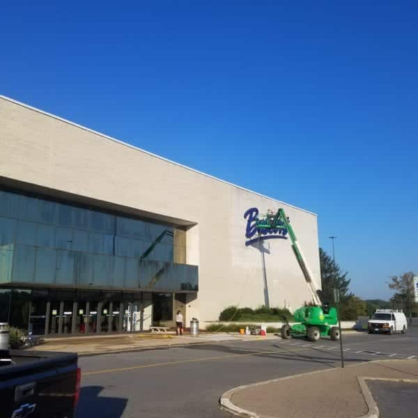 A construction lift is parked outside a large building as a "Burlington" sign is being installed. The building, featuring a sleek glass entrance and an elegant beige brick exterior, gleams under the clear blue sky. In the foreground, a small parking lot lays waiting for customers and visitors.

If you're looking to keep your own property looking pristine like this, consider Maryland Pro Wash. Specializing in pressure washing services across Harford County MD, Baltimore County MD, Cecil County MD, Howard County MD, Carroll County MD, Anne Arundel County MD; and even extending into Wilmington DE, New Castle County DE, and Delaware County PA. Whether it’s your home or commercial space that needs revitalizing with professional pressure washing services — trust Maryland Pro Wash to get the job done right in these areas.