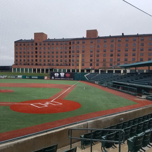 A baseball field is displayed with an unoccupied seating area. Enclosed by a net, the scene features a brick building in the background and outfield walls adorned with various advertisements. Under an overcast sky, this setting is ideal for highlighting Maryland Pro Wash’s pressure washing services, rejuvenating fences, buildings, and outdoor spaces across Harford County MD, Baltimore County MD, Cecil County MD, Howard County MD, Carroll County MD, Anne Arundel County MD. They also extend their exceptional cleaning expertise to Wilmington DE, New Castle County DE, and Delaware County PA. Transform lackluster sports venues or any property with Maryland Pro Wash's superior pressure washing service today.