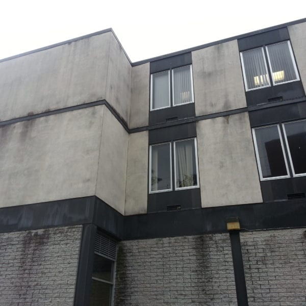 Maryland Pro Wash specializes in revitalizing structures just like this low-rise building with a grey, concrete facade and large windows. If you're noticing signs of weathering and discoloration on your buildings in Harford County, Baltimore County, Cecil County, Howard County, Carroll County, Anne Arundel County in Maryland or even Wilmington and New Castle County in Delaware as well as Delaware County in Pennsylvania, our expert pressure washing services can restore their original charm. With evenly spaced windows and a brick wall forming the lower portion of your building's exterior, our state-of-the-art equipment will ensure every inch is thoroughly cleaned to perfection. Under an overcast sky or bright sunshine, Maryland Pro Wash is committed to making your buildings look their best regardless of the weather conditions. Let us help bring new life to your structure today!