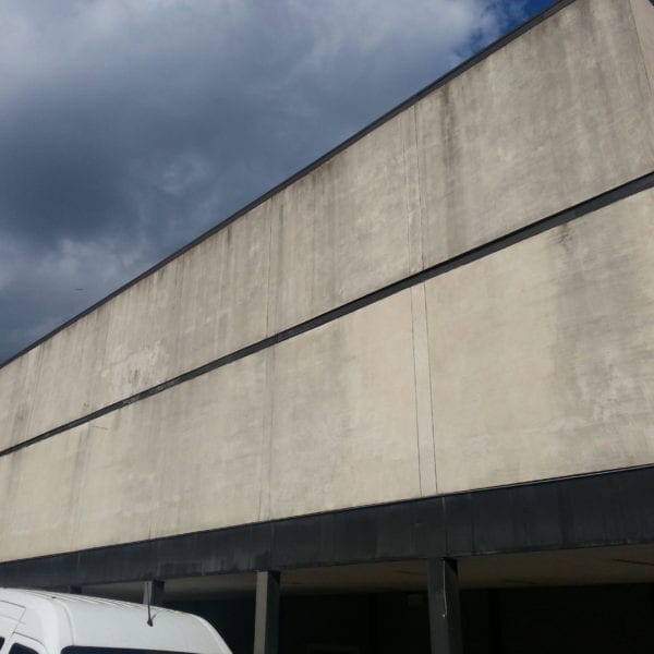 In the heart of a bustling urban area stands a large, concrete building epitomizing minimalist design with its clean lines and flat roof. The rectangular windows allow for an abundance of natural light, while the partly cloudy sky casts dynamic shadows across the building’s surface. A white vehicle is partially visible in the foreground, hinting at the presence of Maryland Pro Wash.

Specializing in pressure washing services, Maryland Pro Wash proudly serves Harford County MD, Baltimore County MD, Cecil County MD, Howard County MD, Carroll County MD, Anne Arundel County MD along with Wilmington DE and New Castle County DE. They extend their meticulous expertise to Delaware County PA as well. Whether dealing with commercial or residential buildings like this one or other surfaces needing rejuvenation through expert pressure washing techniques – Maryland Pro Wash stands ready to enhance curb appeal by removing grime and restoring buildings to their pristine state.