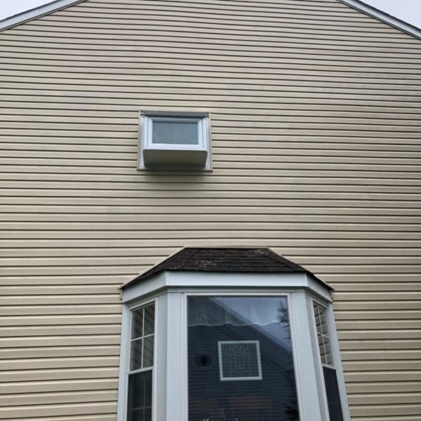 A house with light beige siding stands as a perfect canvas to showcase the transformative power of Maryland Pro Wash's expert pressure washing services. The exterior features two distinct windows: a charming small rectangular window nestled near the roof and, beneath it, an elegant larger bay window adorned with multiple glass panes. The bay window is accented by a dark shingled overhang that adds character and depth to the facade.

Serving numerous areas including Harford County MD, Baltimore County MD, Cecil County MD, Howard County MD, Carroll County MD, and Anne Arundel County MD in Maryland; Wilmington and New Castle County in Delaware; as well as Delaware County in Pennsylvania—Maryland Pro Wash ensures your home’s exterior radiates cleanliness and appeal. Whether it's revitalizing siding or restoring windows to their pristine condition, Maryland Pro Wash renews homes like this one across these regions with precision and care.