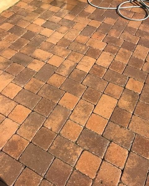 Maryland Pro Wash provides professional pressure washing services to rejuvenate surfaces like sunlit patios made of interlocking rectangular bricks in varying shades of brown. If your patio has accumulated dirt and grime or if a coiled garden hose is just not enough, our expert team can help restore its original beauty. Serving Harford County MD, Baltimore County MD, Cecil County MD, Howard County MD, Carroll County MD, Anne Arundel County MD, Wilmington DE, New Castle County DE, and Delaware County PA - Maryland Pro Wash employs industry-leading techniques to ensure your outdoor spaces shine under the sunlight once again. Let us handle the hard work so you can enjoy a clean and inviting patio area all year round.
