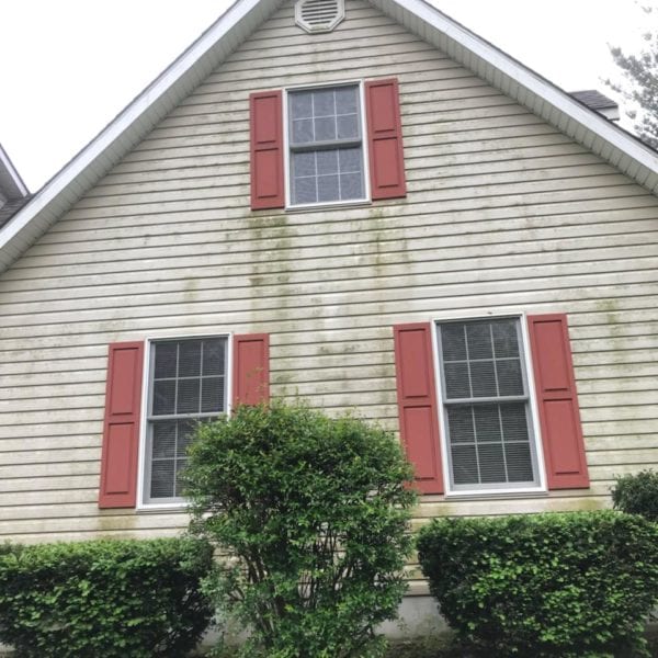 A charming house with vertical siding displays three windows, each adorned with striking red shutters. Over time, the elements have left their mark on the siding, evidenced by subtle green staining that hints at nature's embrace. Below two of the windows, a meticulously trimmed shrub adds a touch of elegance to the home's exterior.

To restore this home to its pristine condition and remove those signs of weathering, you can rely on Maryland Pro Wash for expert pressure washing services. With an extensive service area covering Harford County MD, Baltimore County MD, Cecil County MD, Howard County MD, Carroll County MD, Anne Arundel County MD in Maryland; Wilmington DE and New Castle County DE in Delaware; and Delaware County PA in Pennsylvania—Maryland Pro Wash stands ready to enhance your home’s curb appeal using professional techniques and eco-friendly methods tailored for homes like yours.