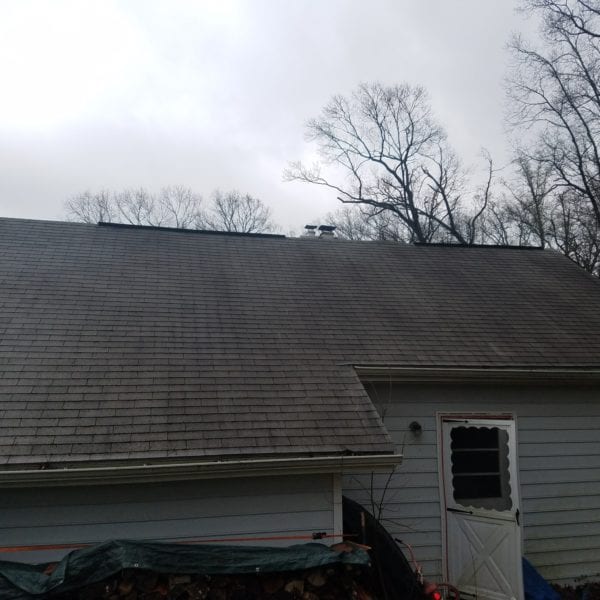 A gray house with a large sloped roof is pictured under a cloudy sky, encapsulating the kind of exterior that Maryland Pro Wash expertly revitalizes. Bare tree branches contrast against the backdrop, illustrating the natural elements homes endure. At the side of the house, a woodpile covered with a tarp and a white door with a black screen hint at areas where dirt and grime accumulate over time—perfect candidates for thorough cleaning by Maryland Pro Wash.

Specializing in pressure washing services across Harford County MD, Baltimore County MD, Cecil County MD, Howard County MD, Carroll County MD, Anne Arundel County MD as well as Wilmington DE and New Castle County DE in addition to Delaware County PA, Maryland Pro Wash ensures every aspect of your property is impeccably cleaned. Whether it’s enhancing curb appeal or maintaining exterior surfaces through professional pressure washing techniques in these areas, you can trust them to deliver remarkable results for any weather-worn structure or surface.